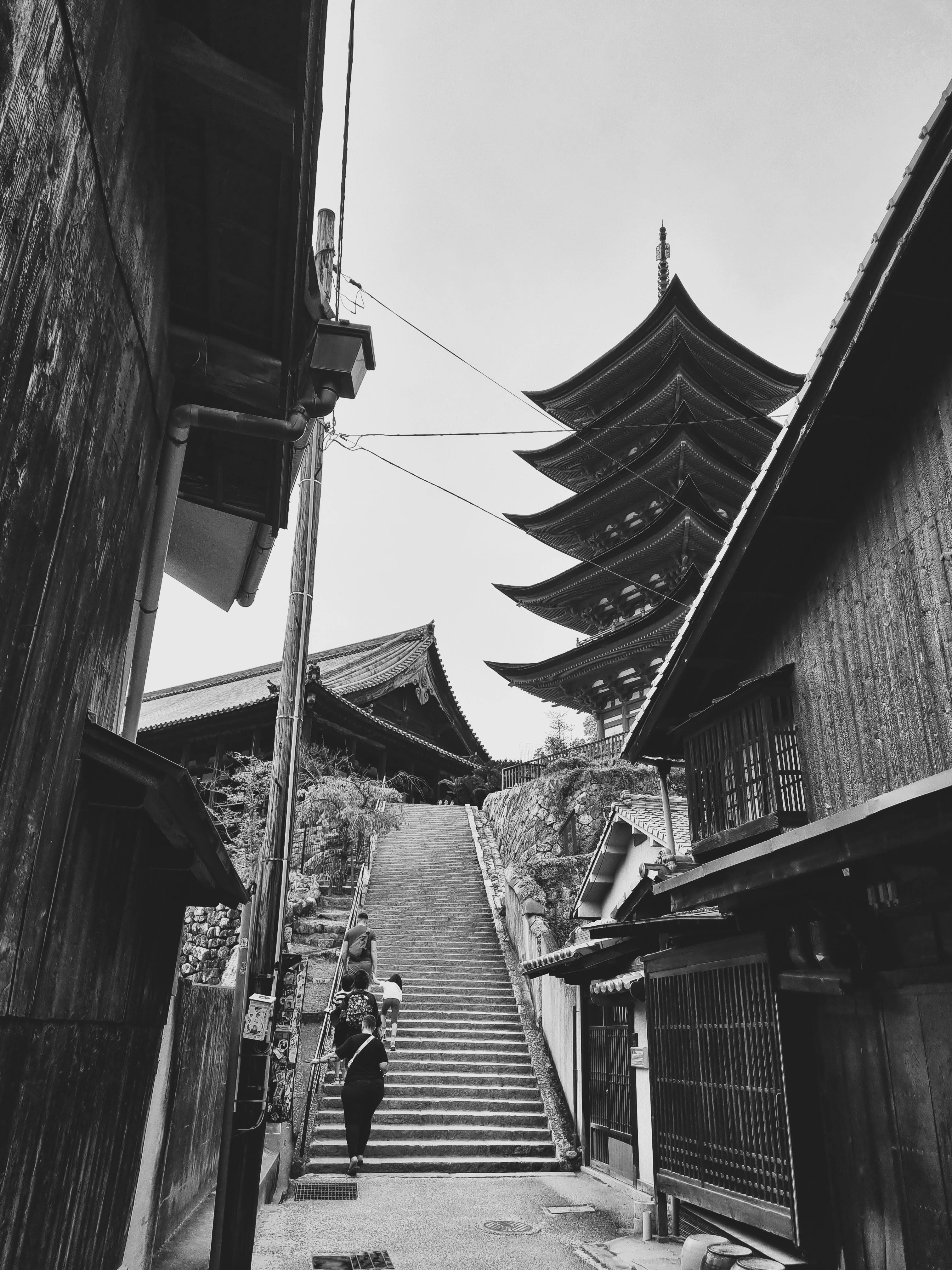 Black and white photograph of a traditional Japanese pagoda and street.