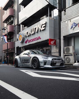 A modified Nissan GT-R sports car on a downtown Tokyo street, showcasing Japanese automotive culture.