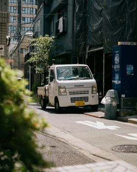 Discover the authentic urban lifestyle of Shinjuku with this serene street scene featuring a Suzuki truck in Tokyo, Japan.