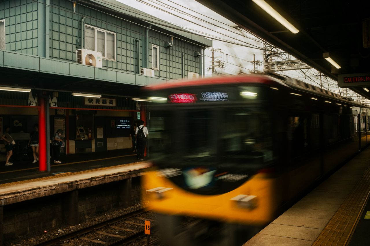 a blurred train rushes past a platform in kyoto japan capturing urban