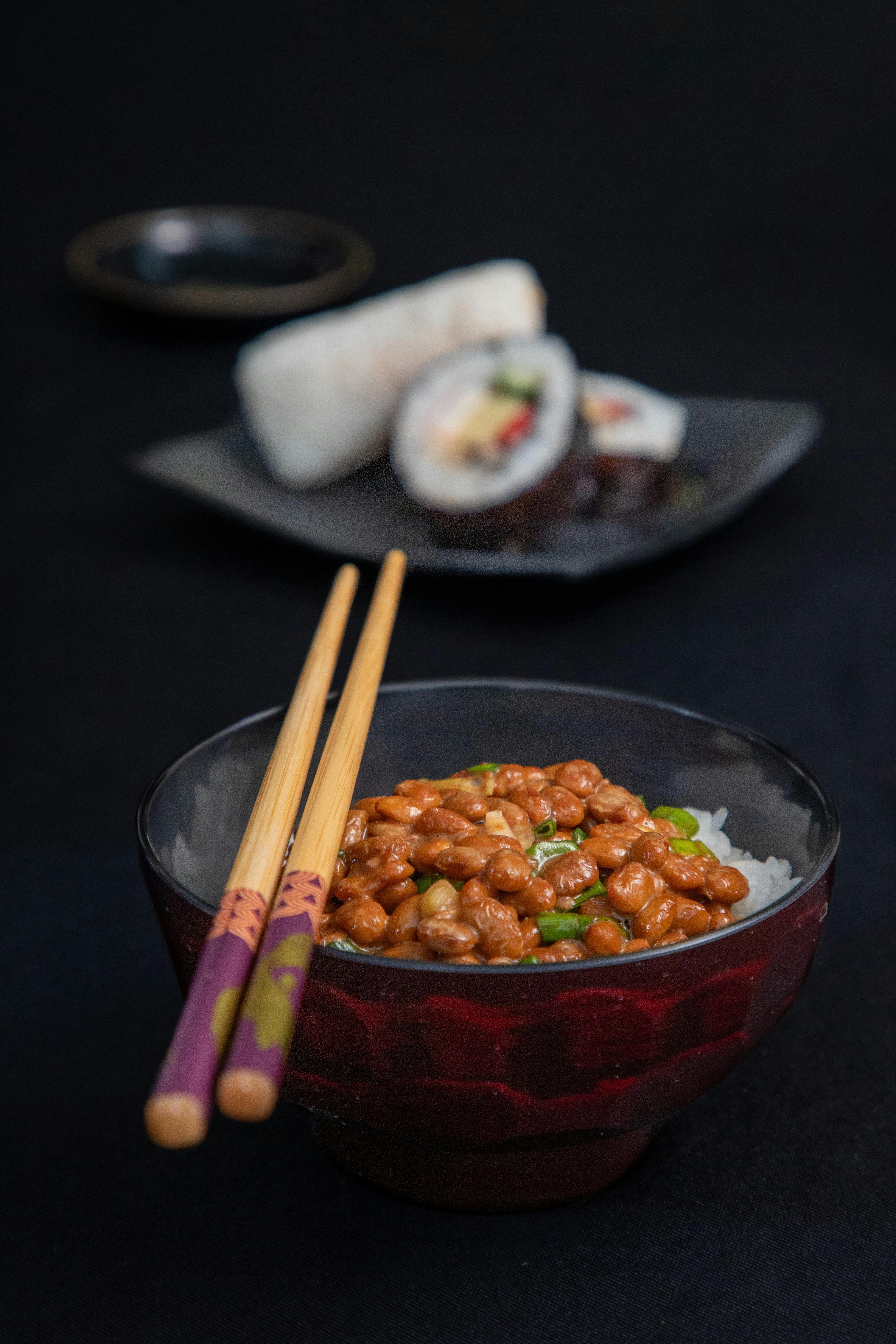 Natto with rice and sushi roll in elegant dishware. A taste of Japanese cuisine.