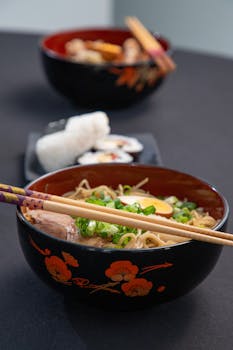Delicious bowl of ramen noodles with sushi on the side. Perfect for Japanese cuisine lovers.