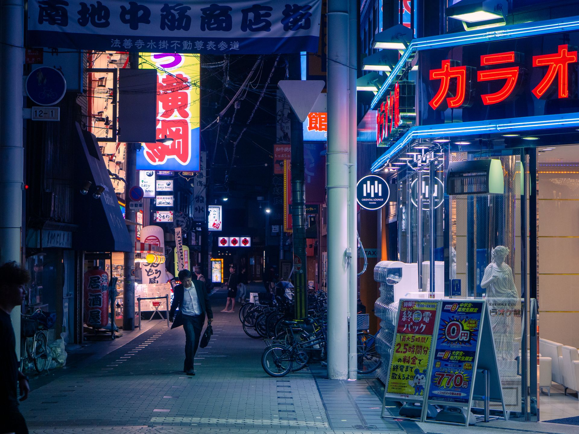 Explore the lively night scene in Osaka, Japan, with neon signs and bustling city life.