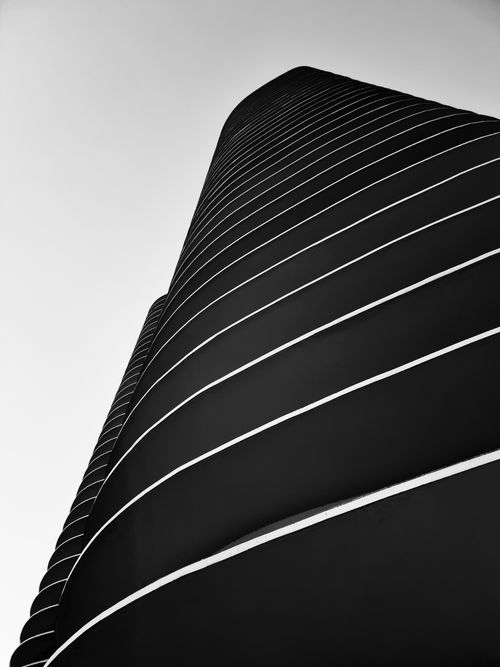 Free Dynamic low-angle view of a modern skyscraper in black and white, highlighting architectural lines. Stock Photo