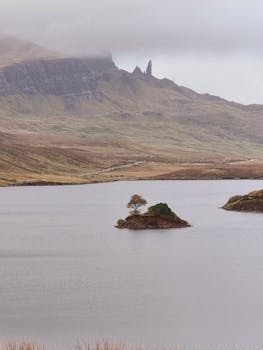 Dramatic landscape of the Old Man of Storr in Scotland with a lake and small island.