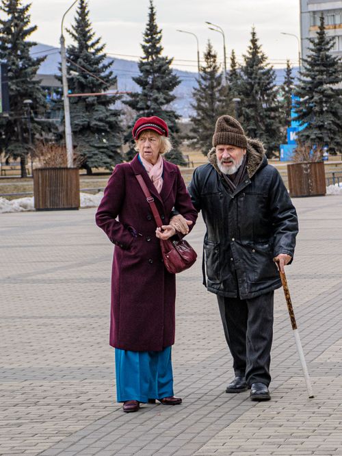 Free Senior couple walking outdoors in winter attire, showcasing companionship. Stock Photo