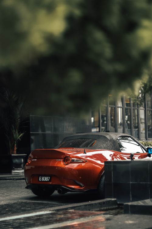 Free Stylish red sports car parked on a wet street in Kuala Lumpur, Malaysia. Stock Photo