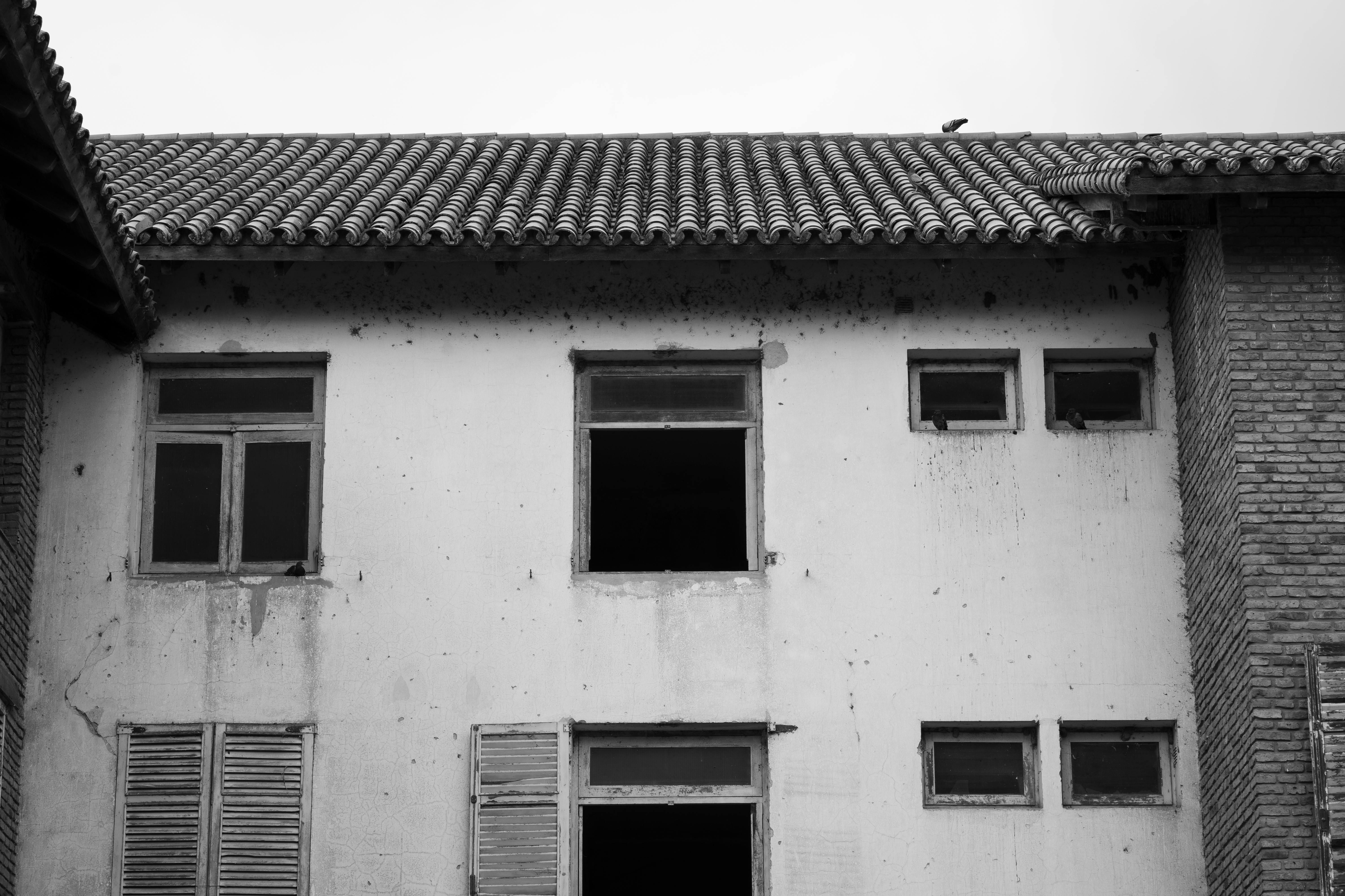 grátis Foto em preto e branco da fachada de um prédio abandonado em Embalse, ilustrando a decadência. Foto profissional