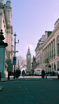 Street view of Big Ben in London with classic architecture and a clear sky.