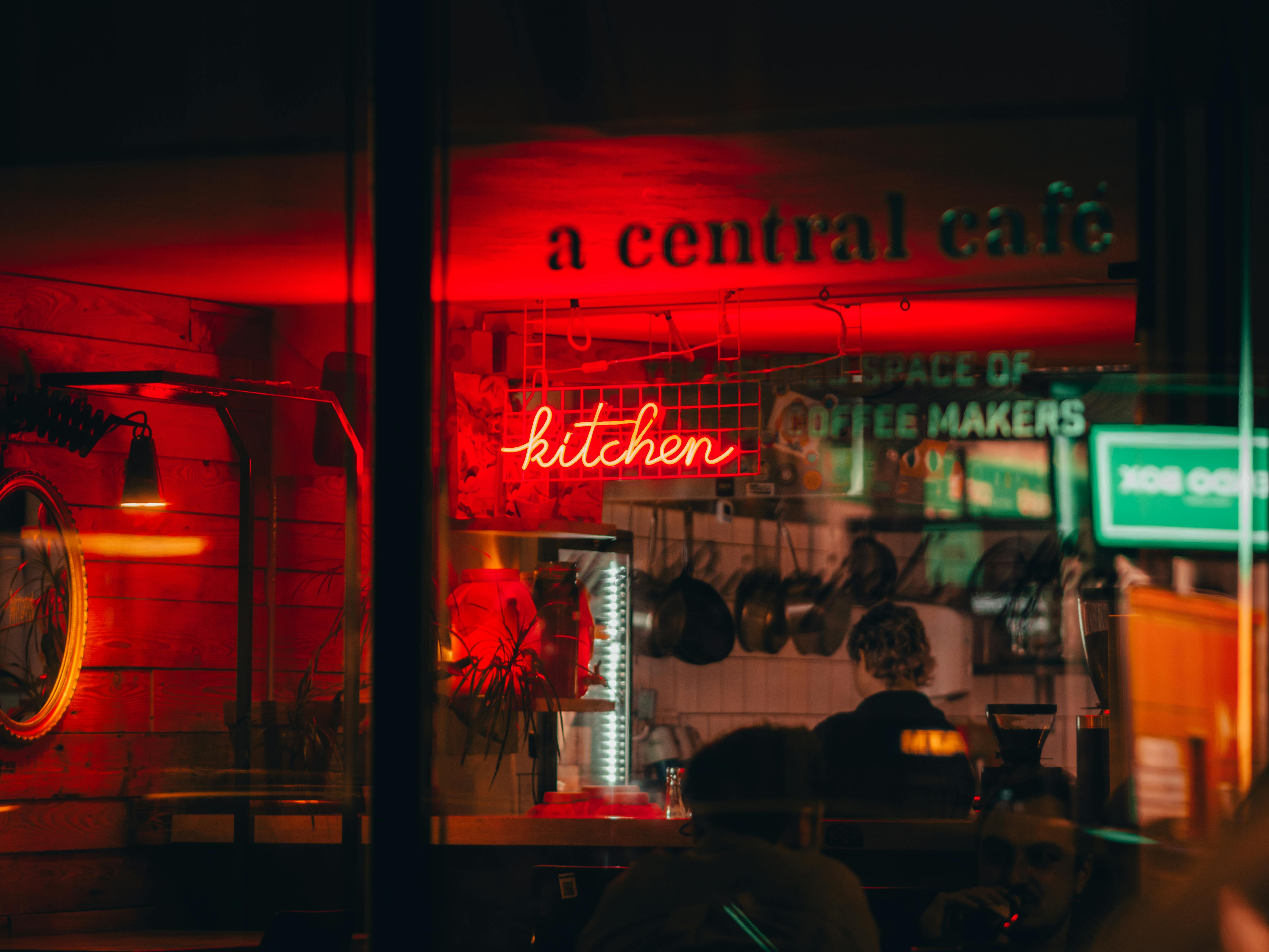 common:alt.prefix Bức ảnh ấm áp và hấp dẫn về một quán cà phê ở Budapest với biển hiệu bếp neon và ánh sáng tạo cảm giác ấm áp. common:alt.postfix