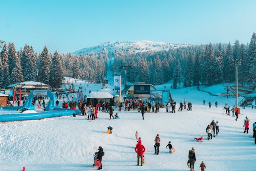 Lively winter day at Kopaonik ski resort, Serbia, with skiers enjoying snow and mountain views.