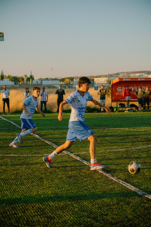 Free Teenagers playing soccer on a sunny outdoor field with dynamic action. Stock Photo