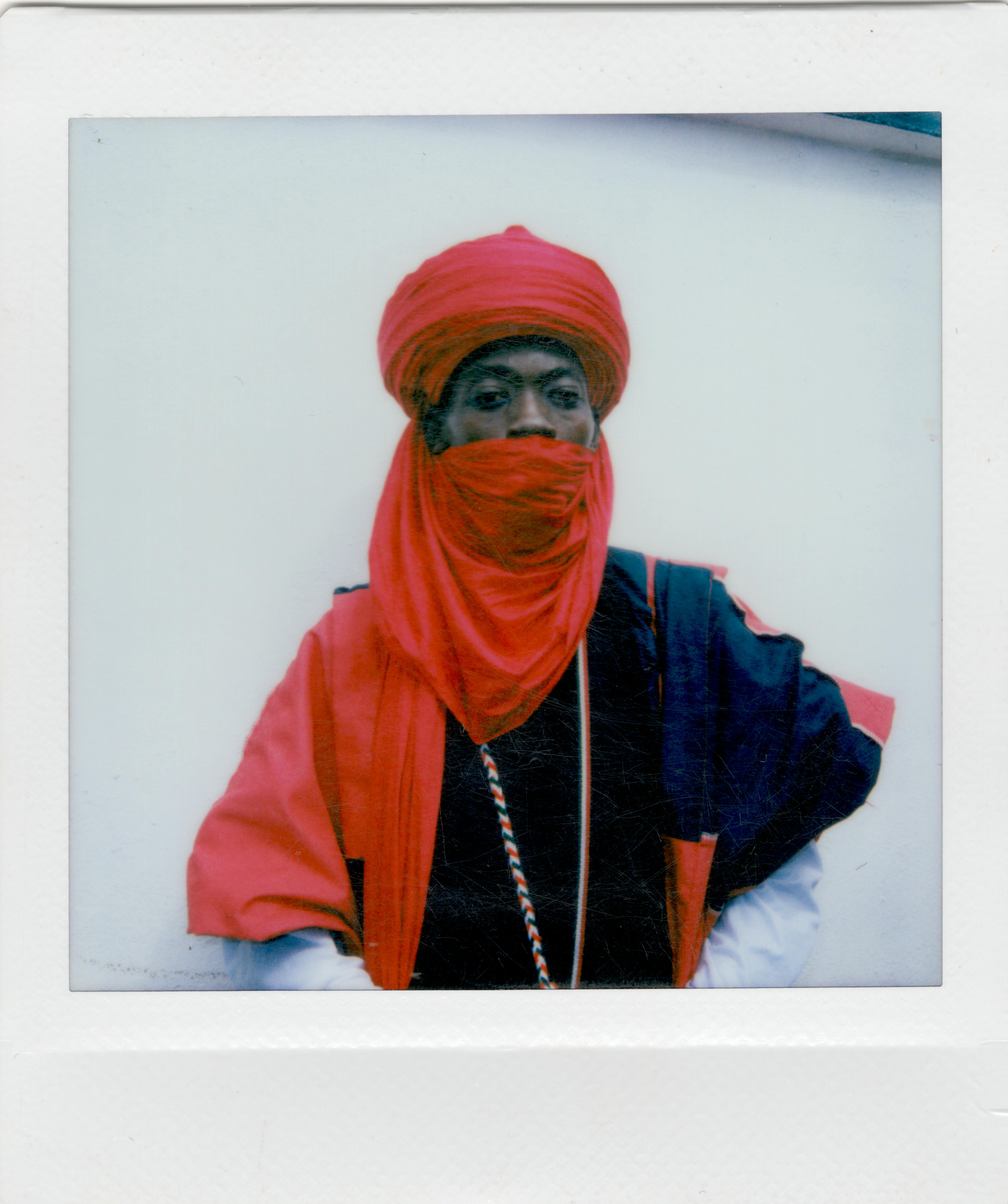 A striking portrait of an individual in vibrant red traditional attire, focusing on cultural fashion.