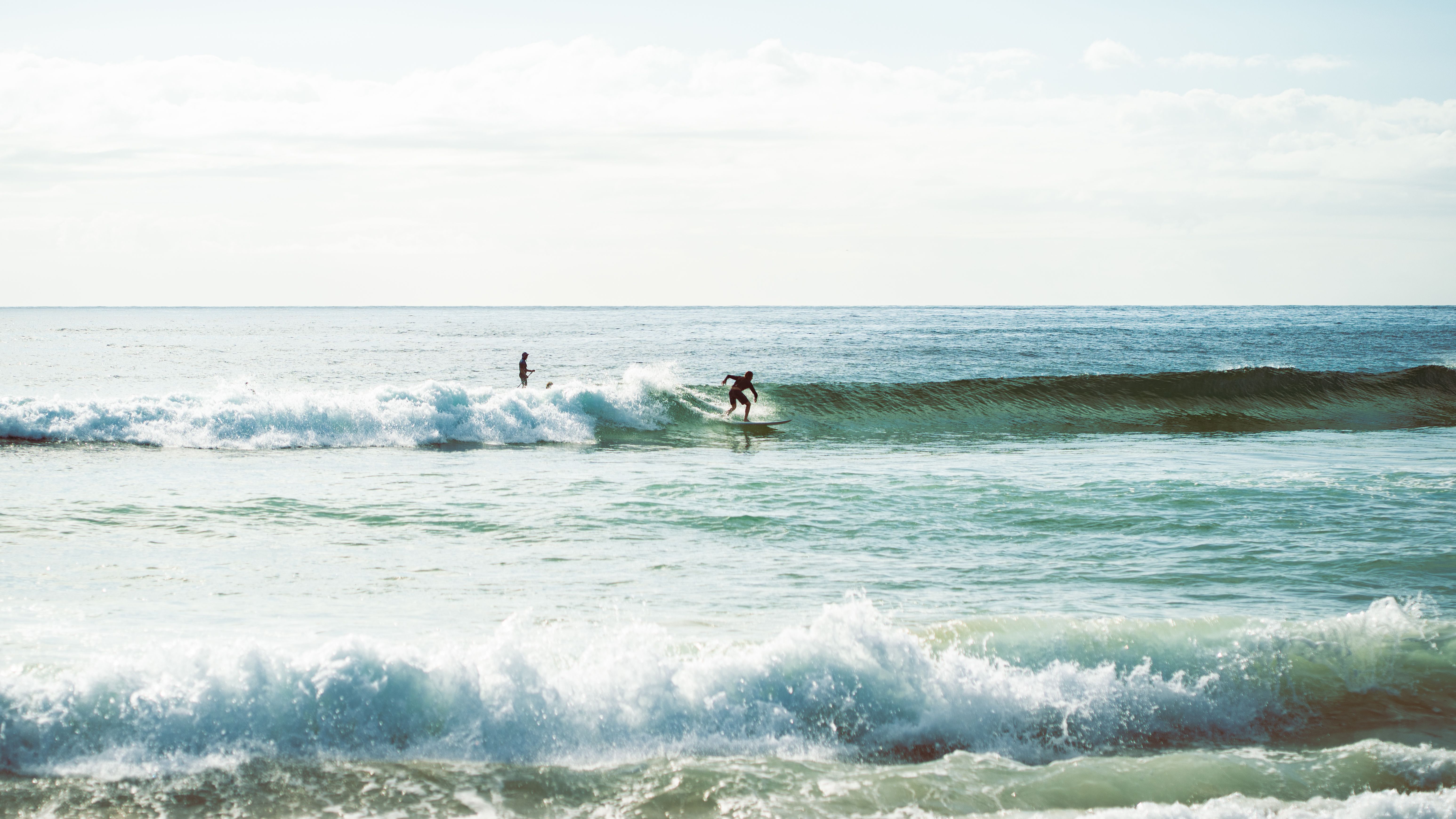 Surfing adventure on sunny Wollongong beach with surfers riding the waves of the Pacific Ocean.