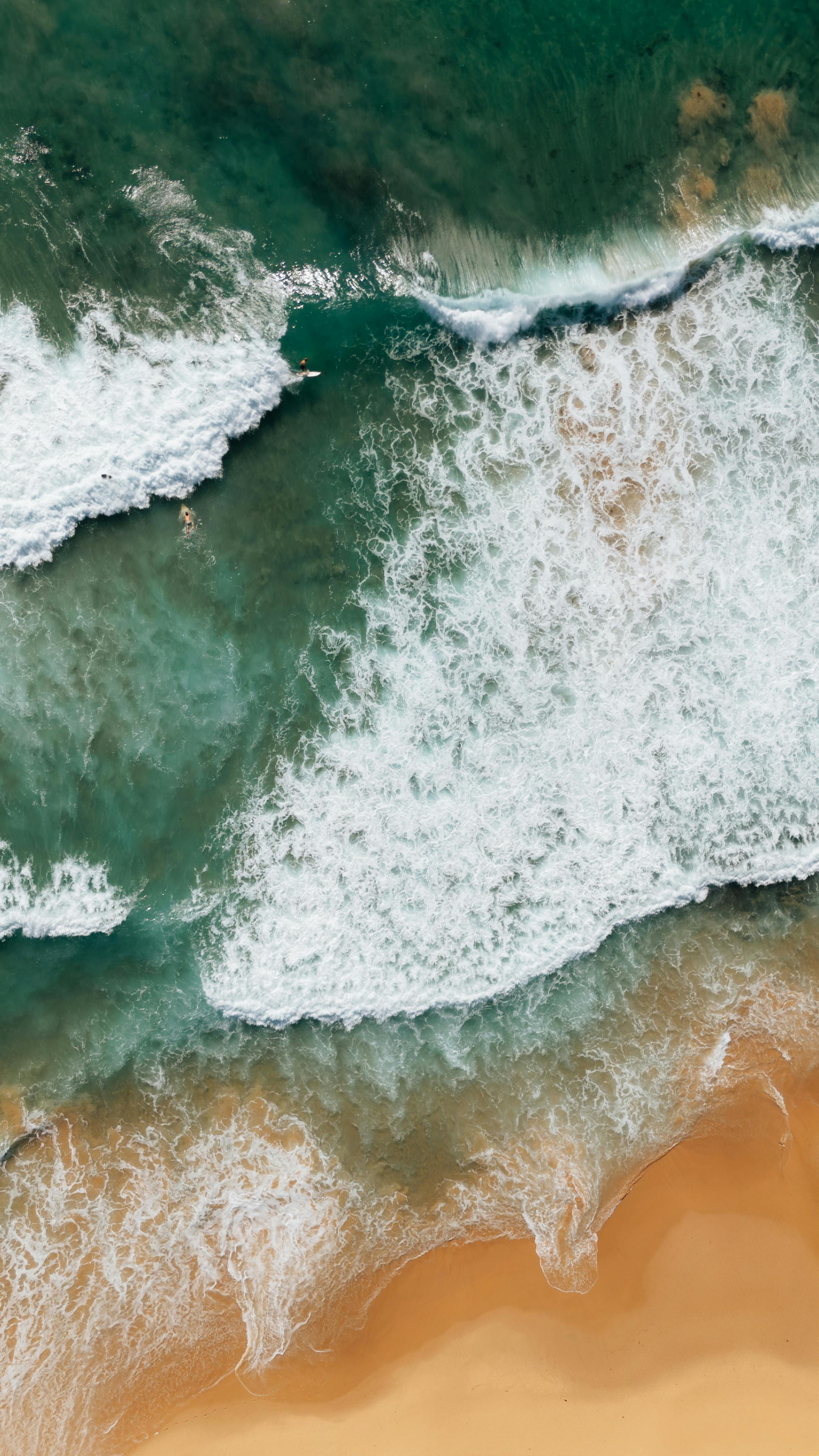 Stunning aerial shot of waves meeting the sandy shore at Wollongong Beach.