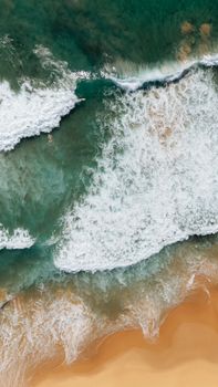 Stunning aerial shot of waves meeting the sandy shore at Wollongong Beach.