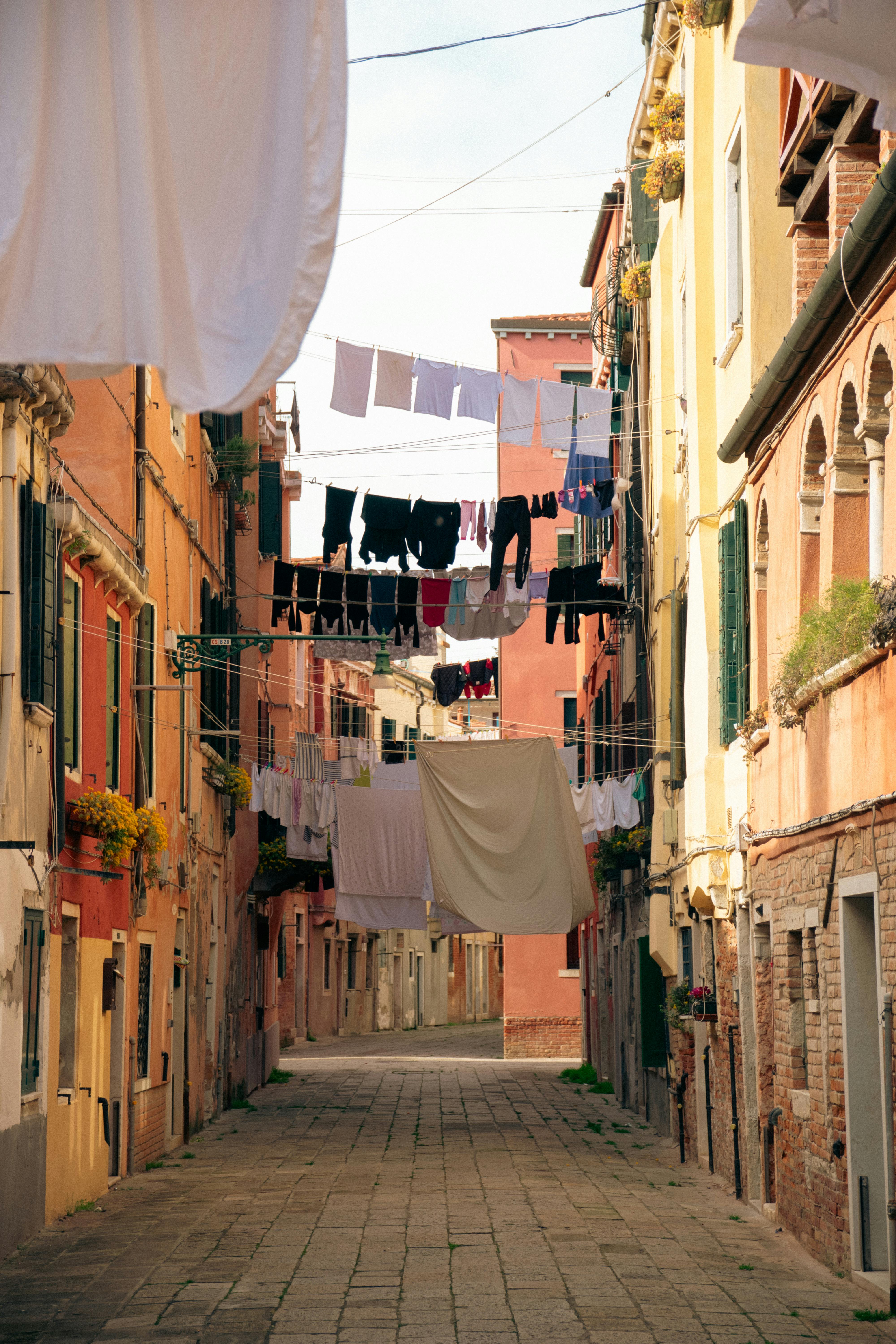 Quaint Venetian street in Italy with colorful buildings and drying laundry.