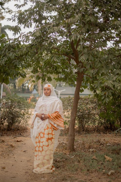 Free Elegant African woman stands outdoors in traditional attire, embodying cultural grace. Stock Photo