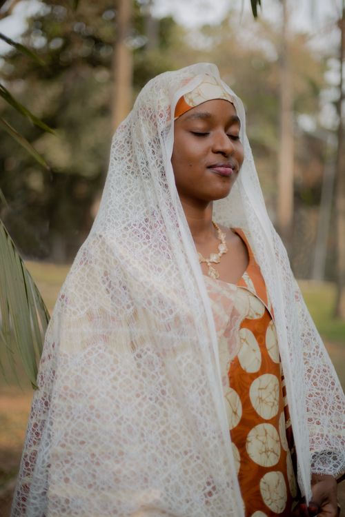 Free Portrait of an African woman in traditional clothing with eyes closed, enjoying a serene moment outdoors. Stock Photo