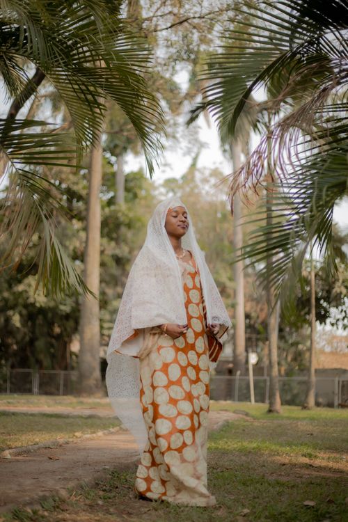 Free A serene portrait of an African woman in traditional attire, set against a lush outdoor backdrop in Abuja, Nigeria. Stock Photo