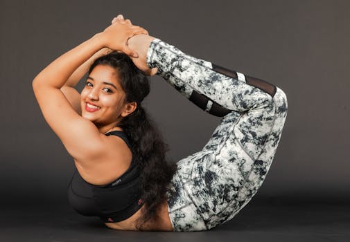 Woman practicing advanced yoga pose indoors, showcasing flexibility and strength.