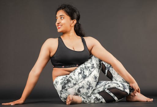 A woman performing a yoga pose indoors, showcasing flexibility and calmness. Ideal for fitness and wellbeing themes.