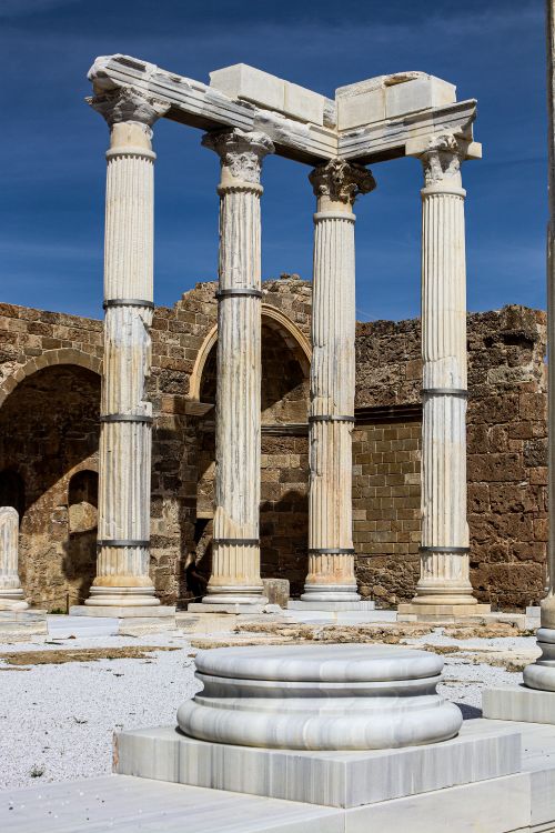 Free Ancient Roman columns against a clear blue sky in Antalya, Türkiye depicting historical architecture. Stock Photo