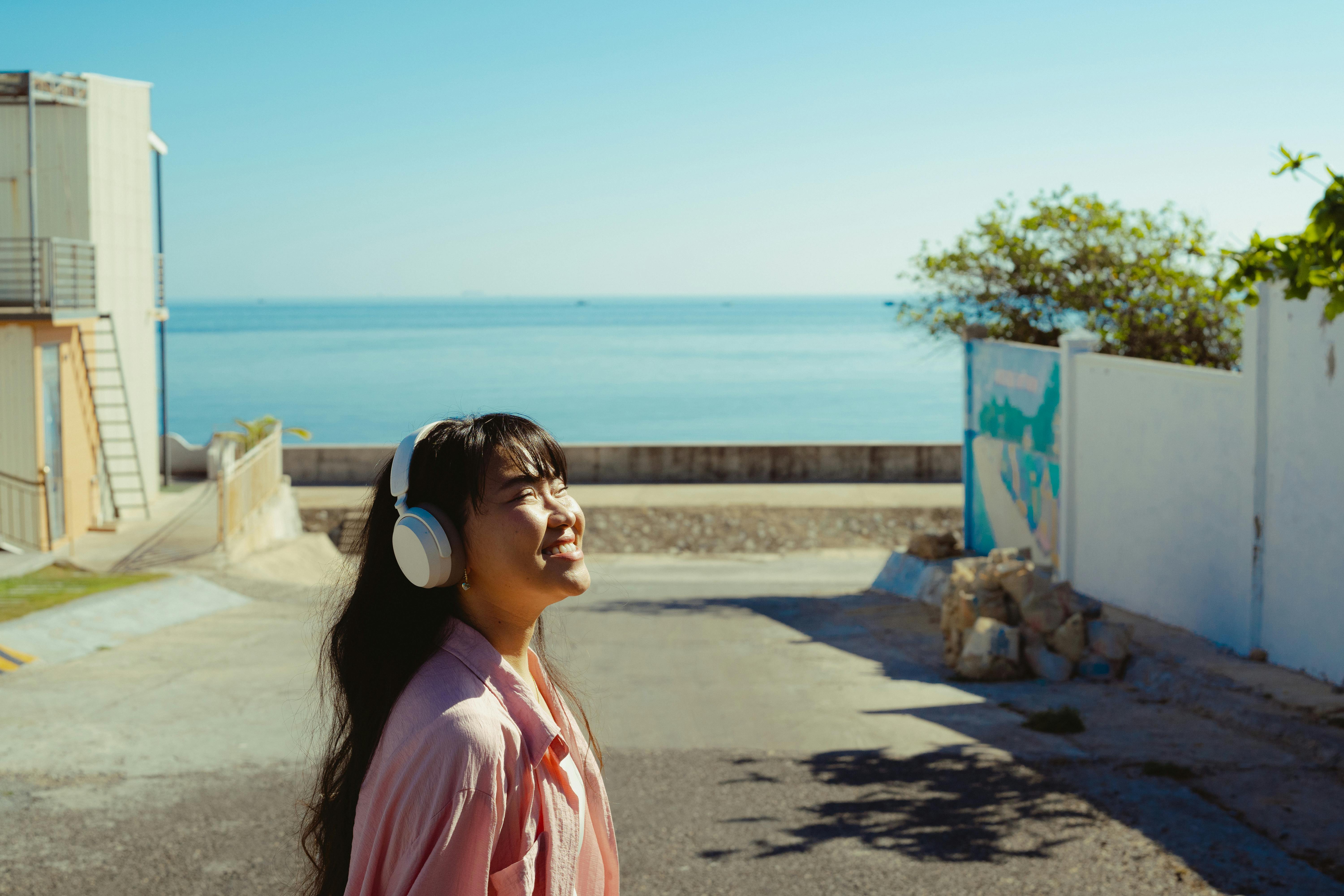 young woman enjoying music by the sea in vietnam