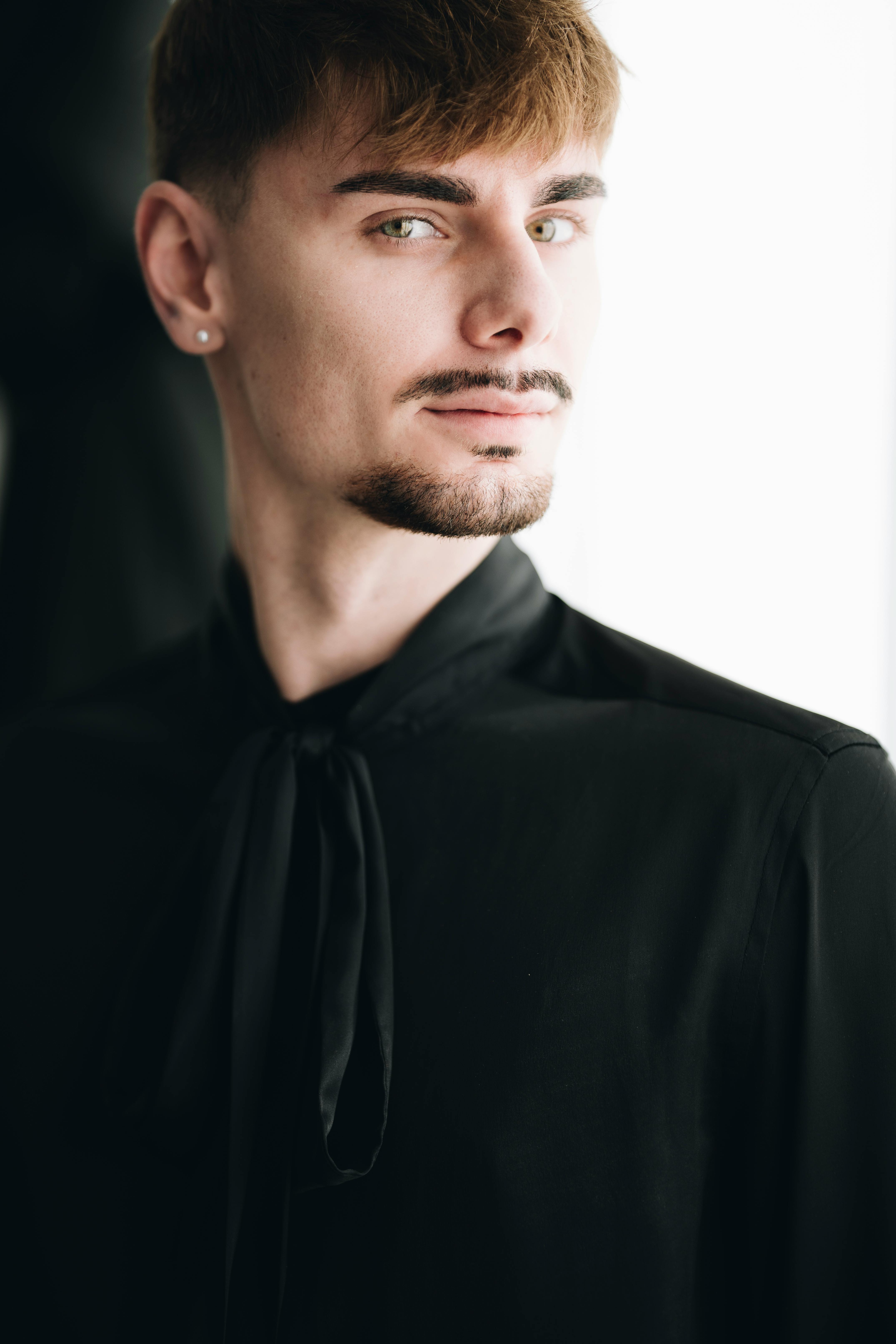 grátis Retrato elegante de um jovem com uma roupa preta estilosa, exalando confiança. Foto profissional