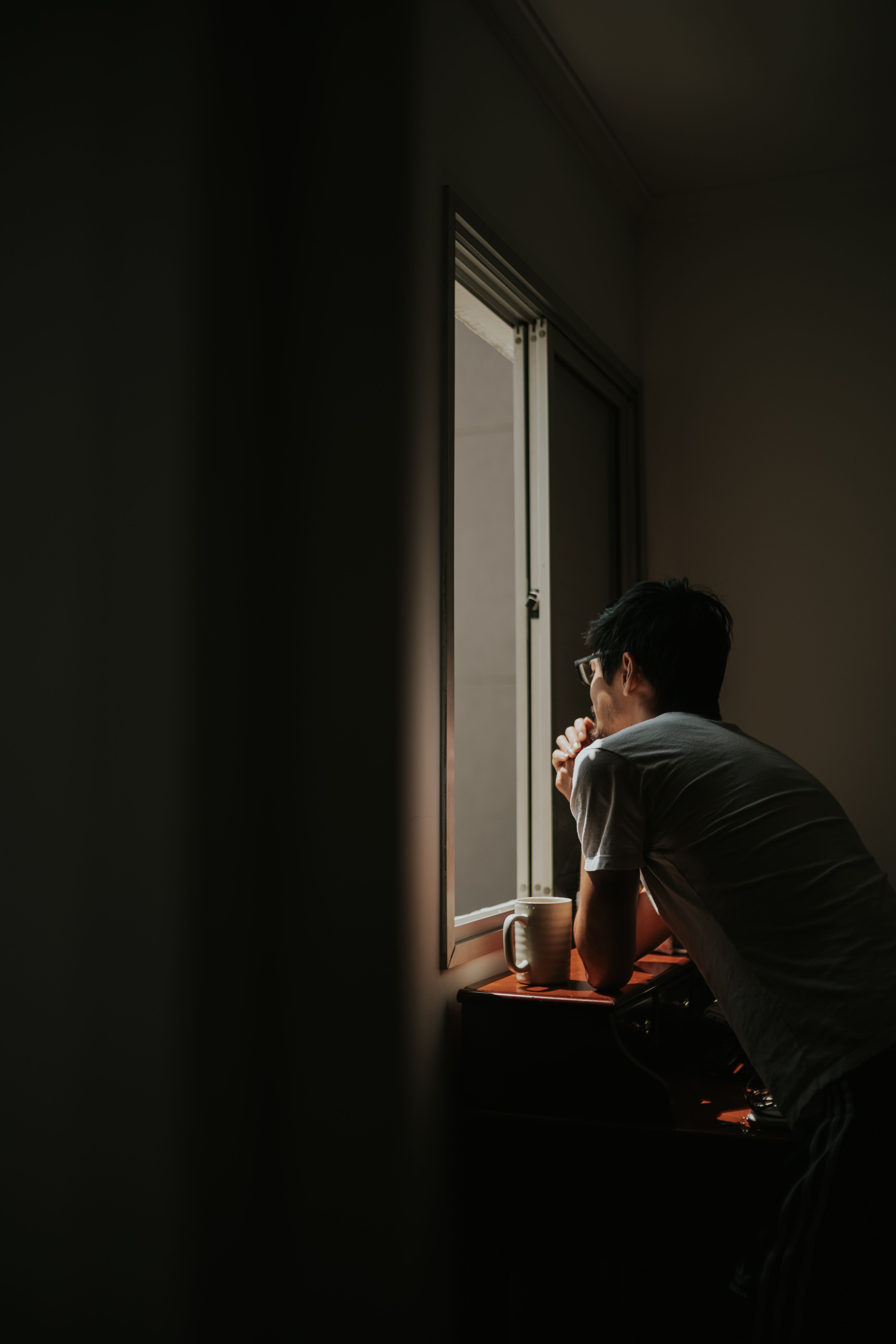 Contemplative Man at Window with Cup · Free Stock Photo