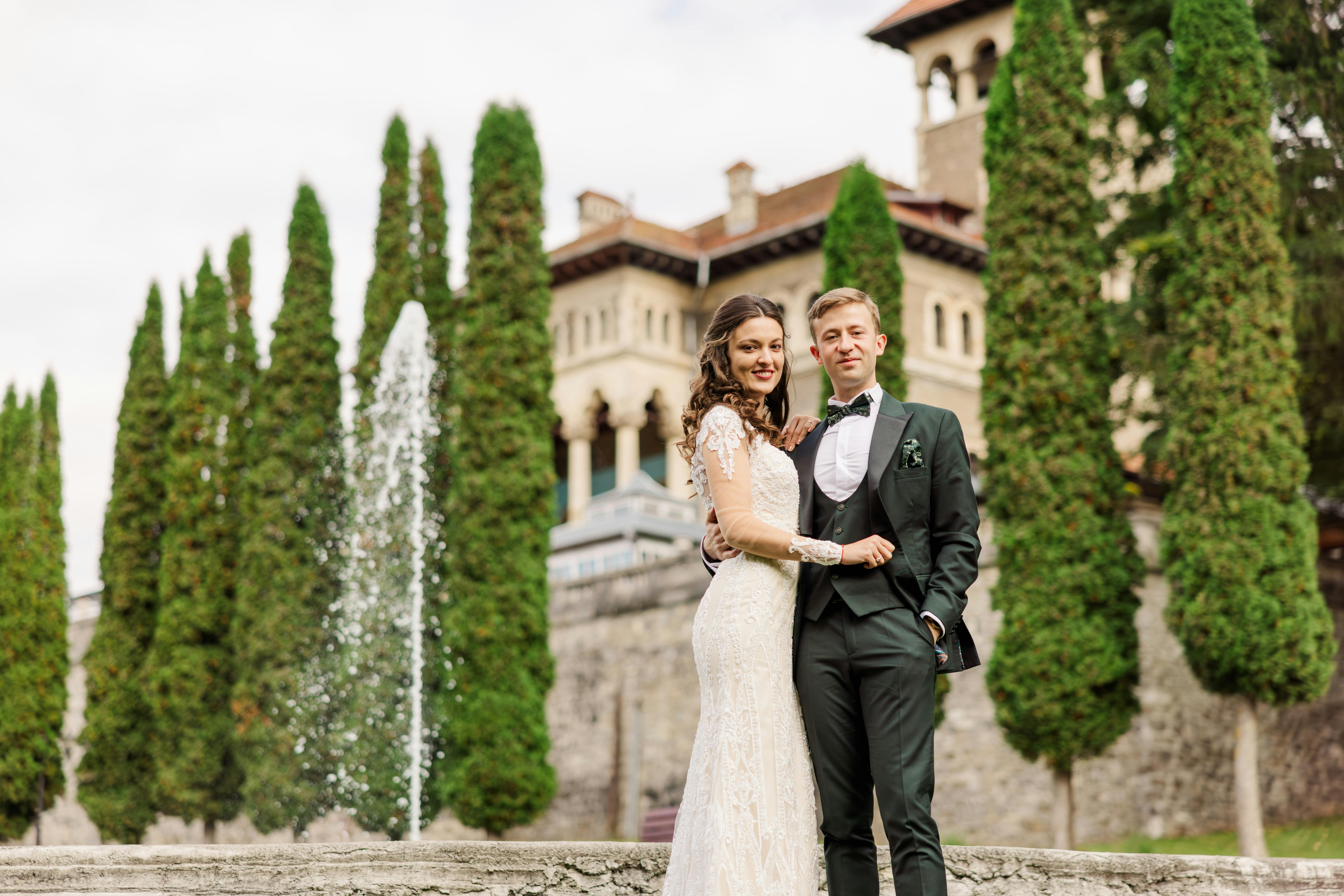 A newlywed couple poses in front of Bușteni's Cantacuzino Castle.