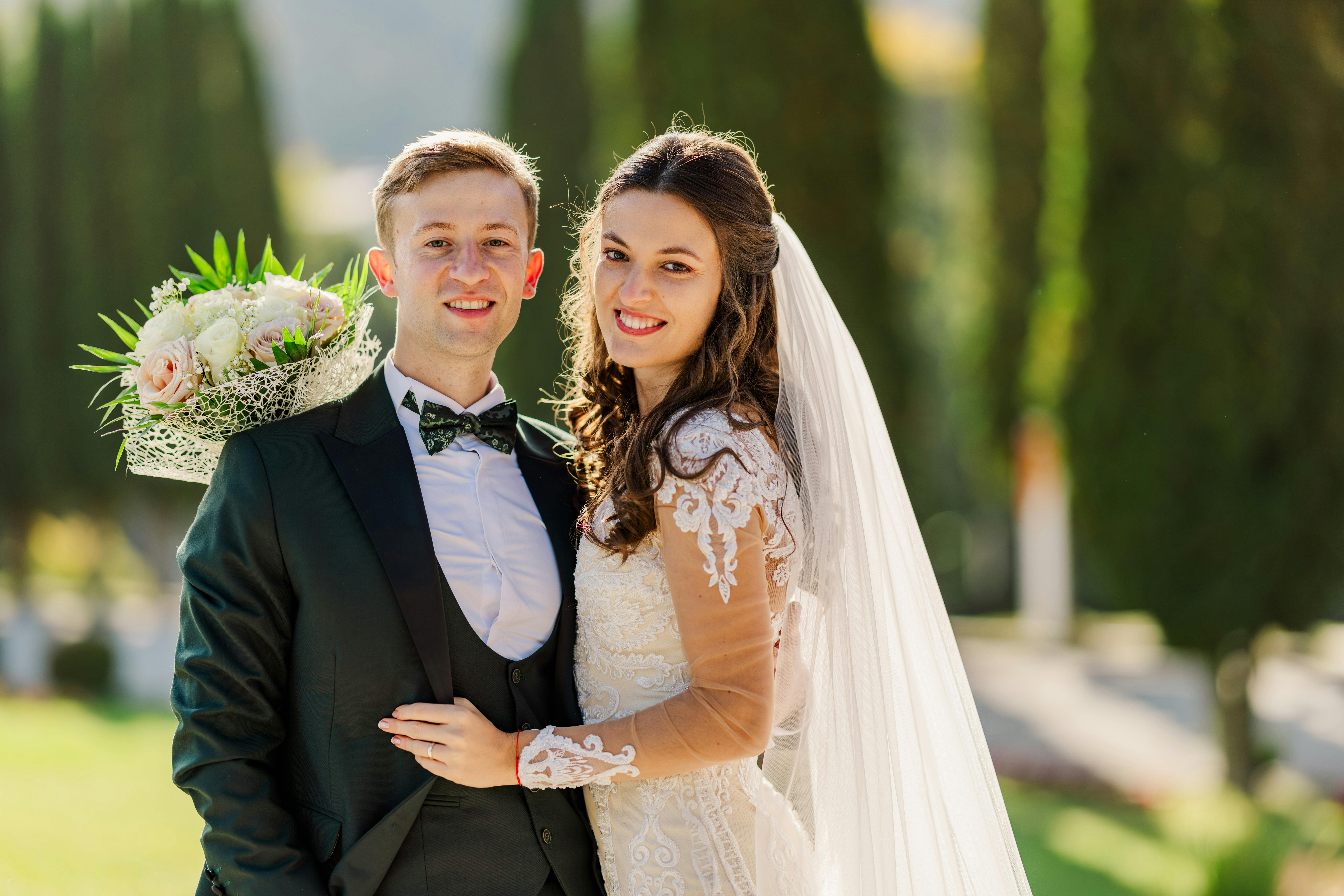 Bride and groom posing with smiles in outdoor wedding setting, Bușteni.