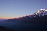 尼泊尔黎明时分，白雪皑皑的山脉与月亮构成令人惊叹的景色