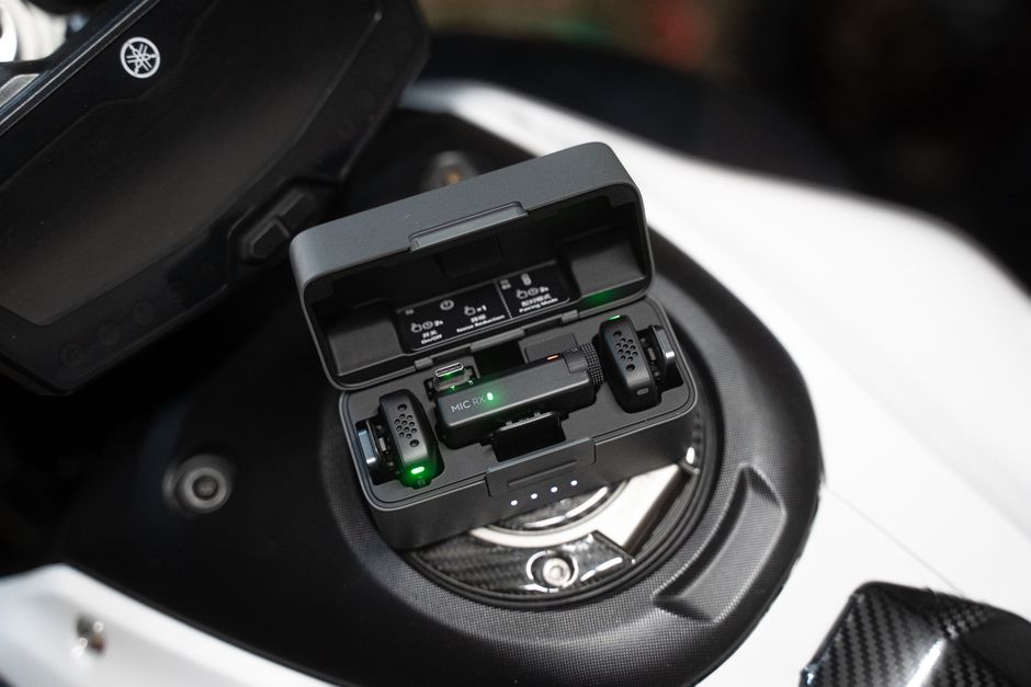Compact microphone set placed on a motorcycle dashboard for audio recording.