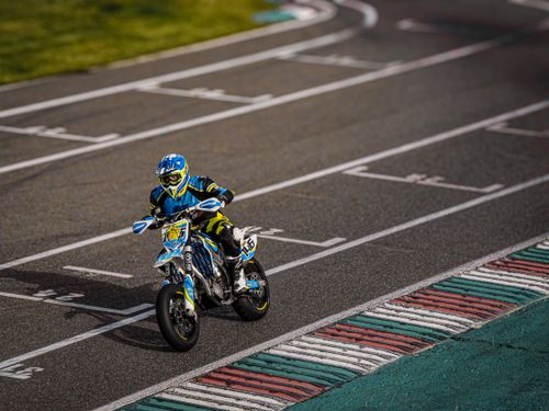 Free Motorcycle racer wearing colorful gear speeds on a track during a competitive race. Stock Photo