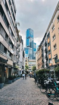 Urban scene featuring a bustling European street with modern skyscrapers in the background.
