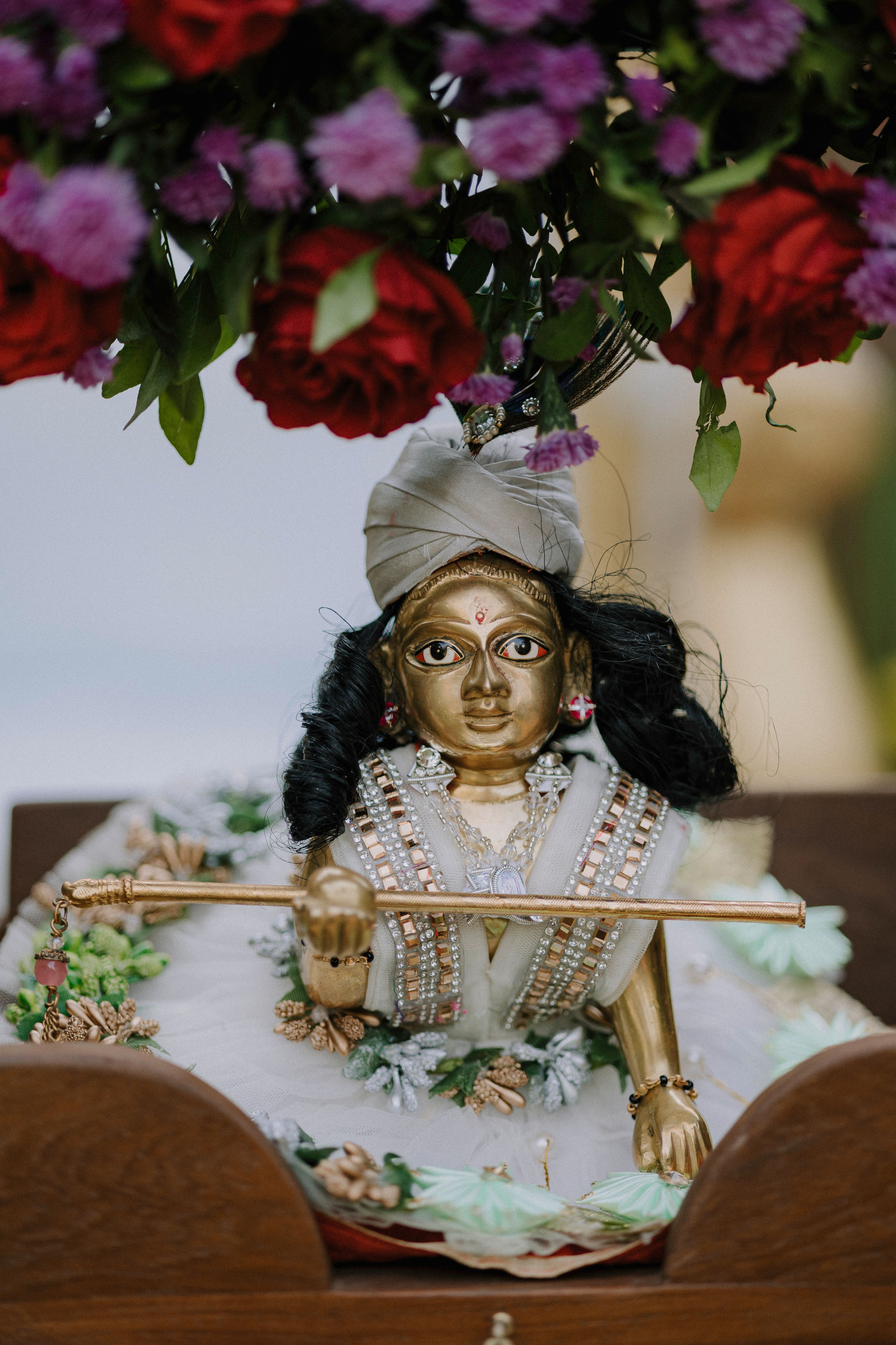 Elegant Krishna idol adorned with vibrant flowers, symbolizing spirituality and devotion.