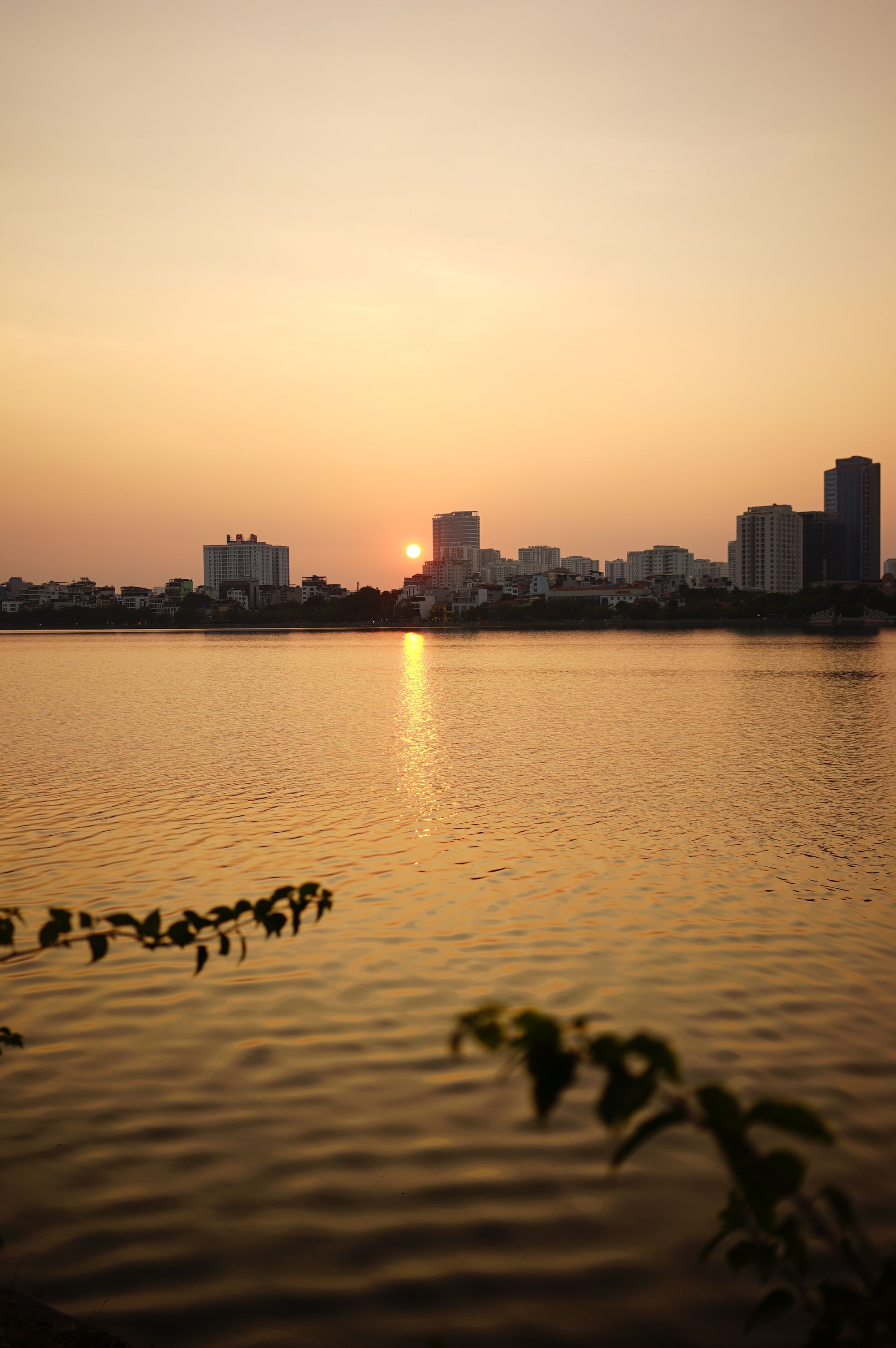 Serene Sunset over City Skyline Reflected in Lake · Free Stock Photo