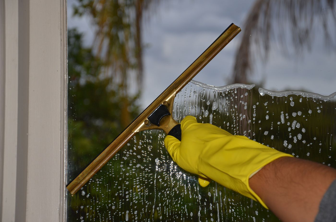 Lavage professionnel d’une vitre avec une raclette à Lyon