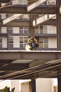 A skilled welder working on a steel structure during a bright day in Tijuana.