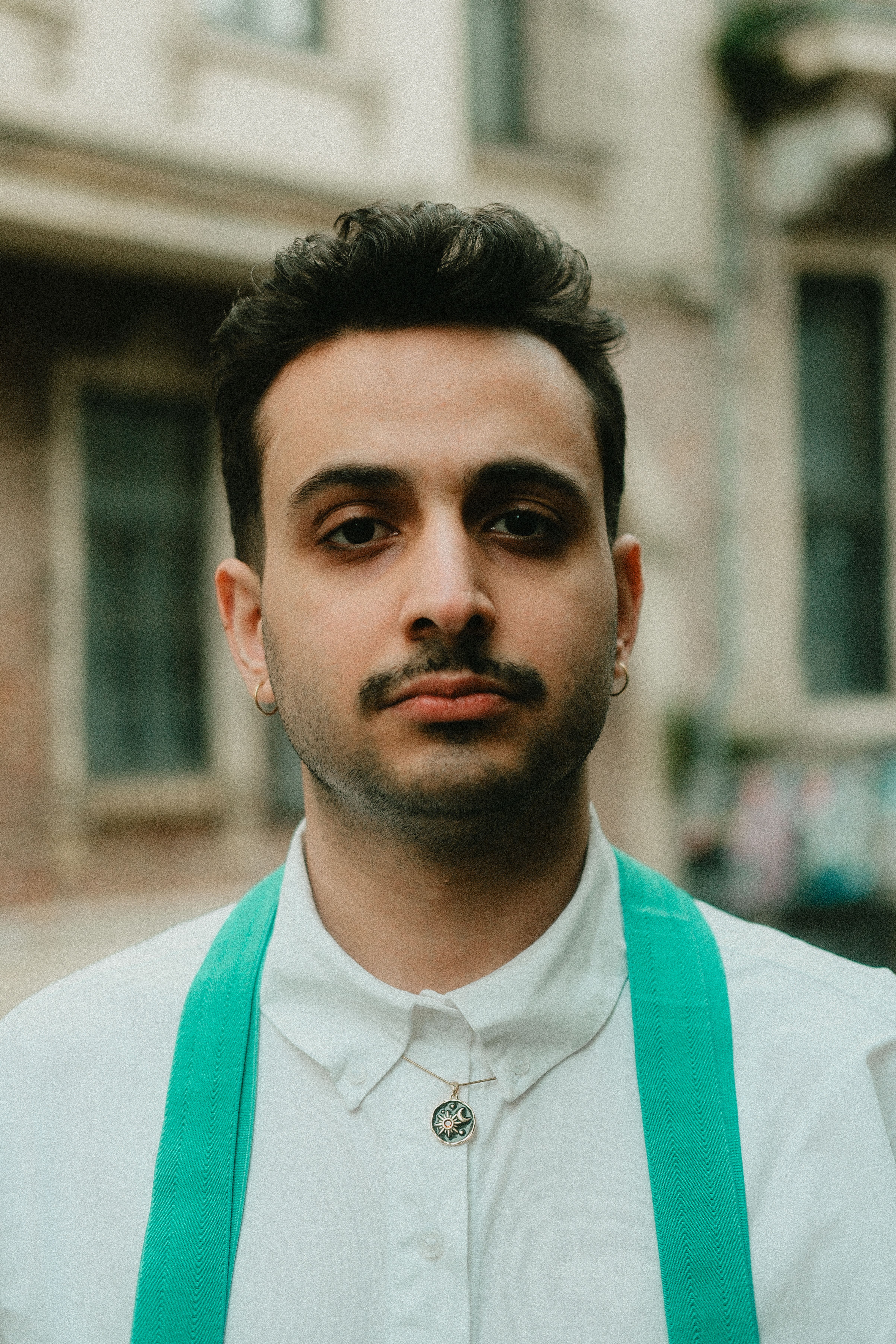 Portrait of a Young Man with Green Suspenders Outdoors