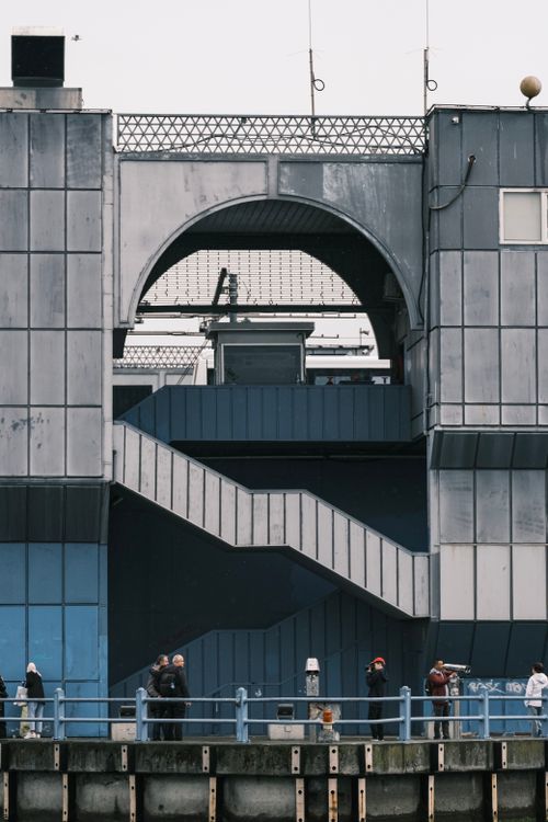 Free A group of people at a modern industrial building with a prominent outdoor staircase. Stock Photo