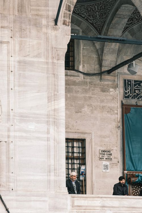 Free Two men standing at Eminonu Yeni Cami Mosque, Istanbul, showcasing Turkish architecture. Stock Photo