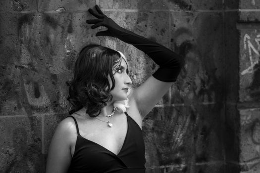 Striking black and white portrait of a woman in character cosplay with stylish black gloves and dress.