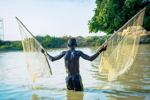 Man fishing with nets in Argungu, Nigeria, showcasing cultural practices.