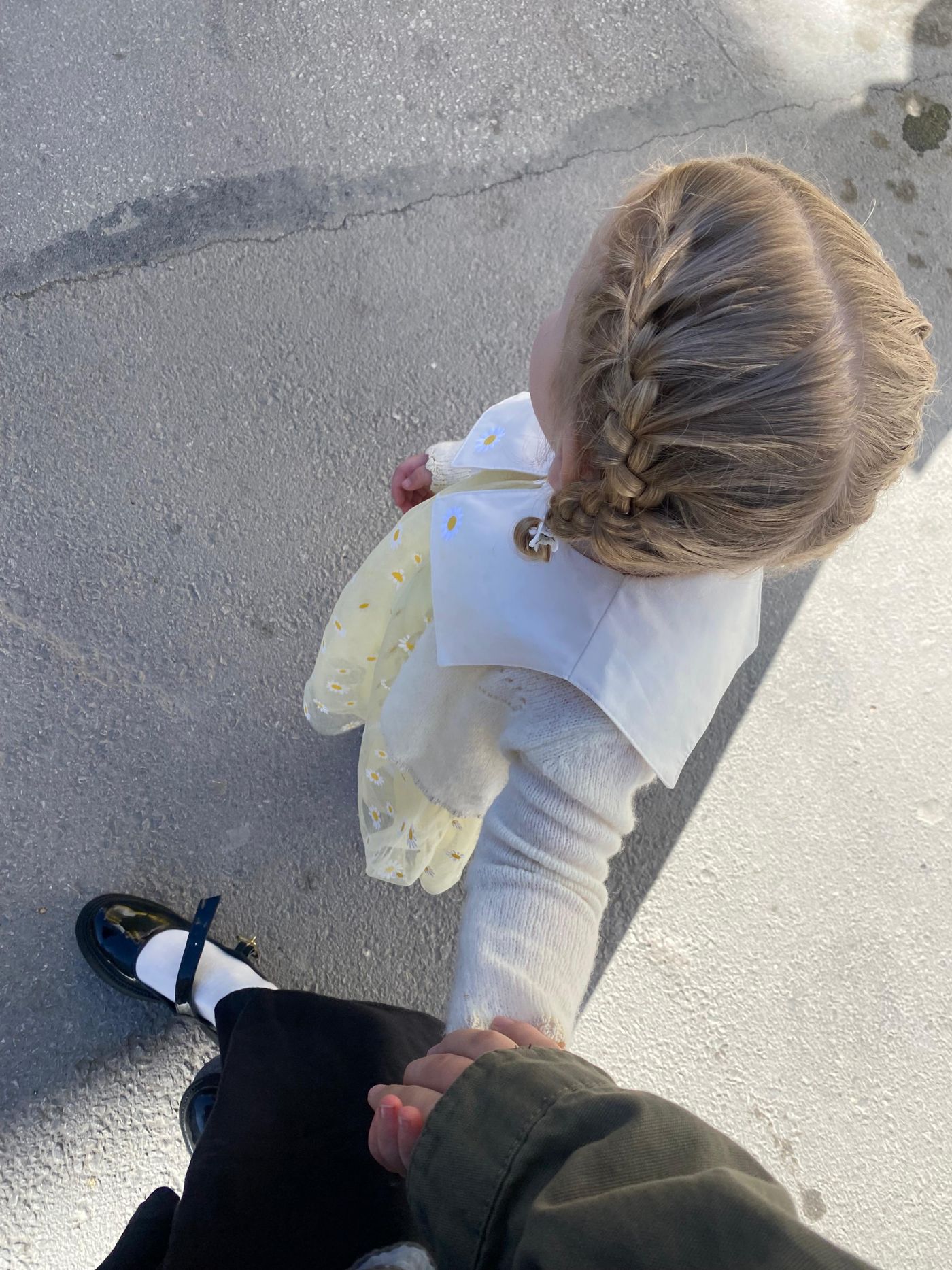 An overhead view of a parent and child holding hands; illustrative stock photograph