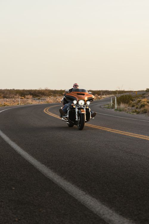 Motorcycle Rider on Scenic Desert Road at Sunset · Free Stock Photo
