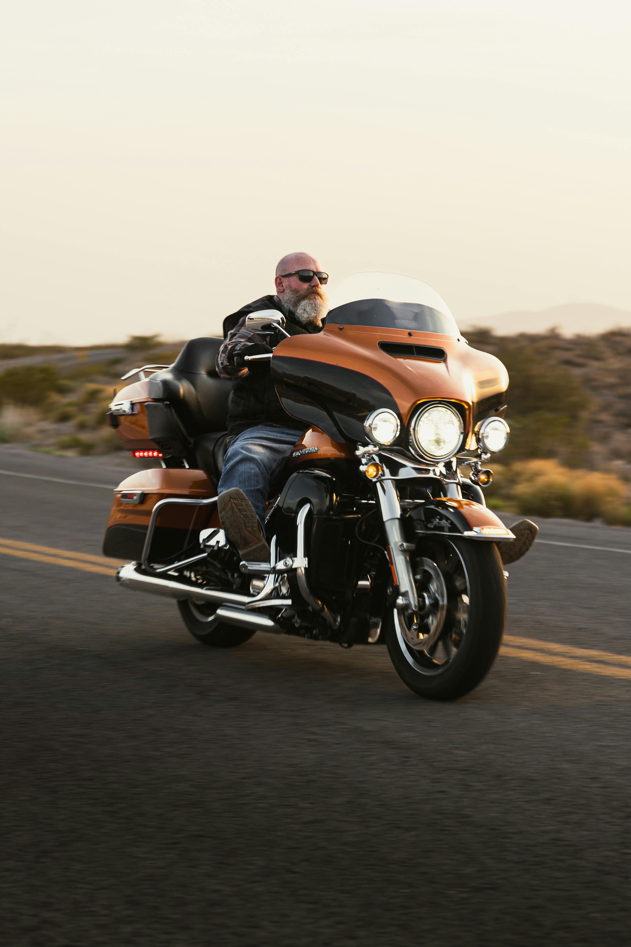 Motorcyclist on Harley Davidson riding along Route 66 at sunset in New Mexico.