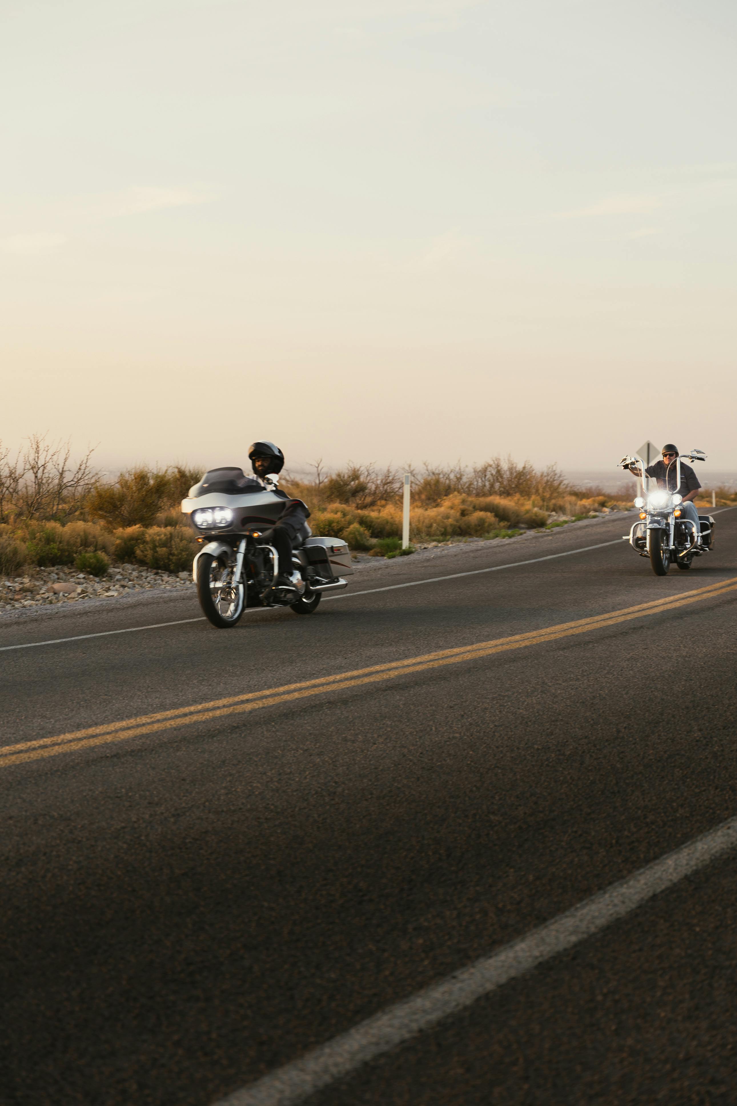 Motorcyclists ride through scenic Route 66 in New Mexico during a beautiful sunset.