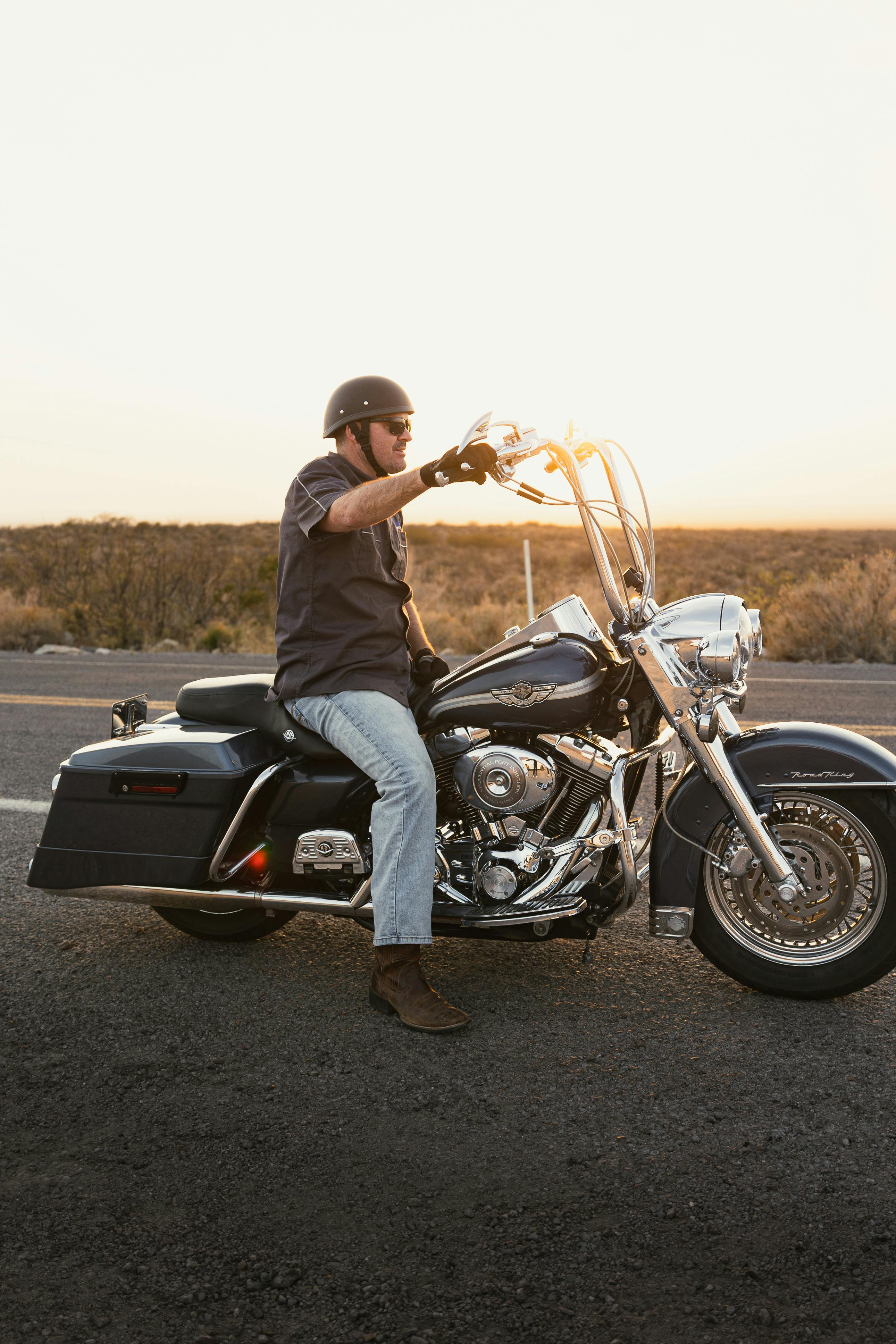 A motorcyclist pauses on a Harley-Davidson during a sunset ride on Route 66 in New Mexico.